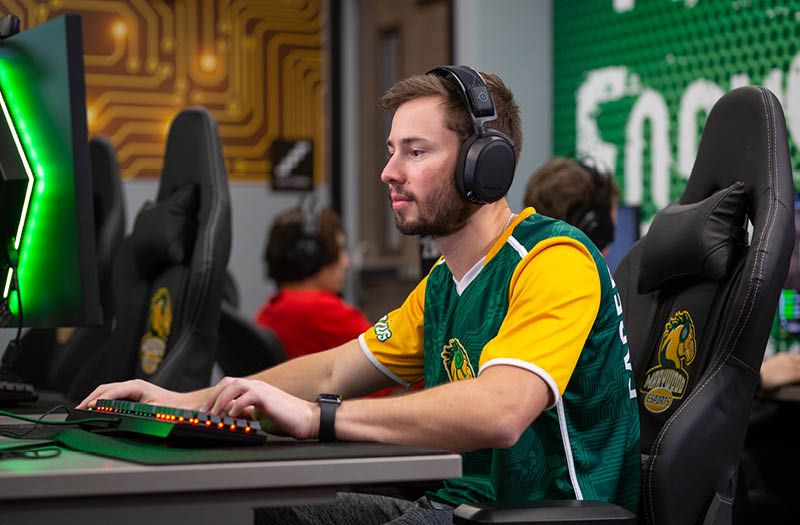 An Esports player sitting at a computer.