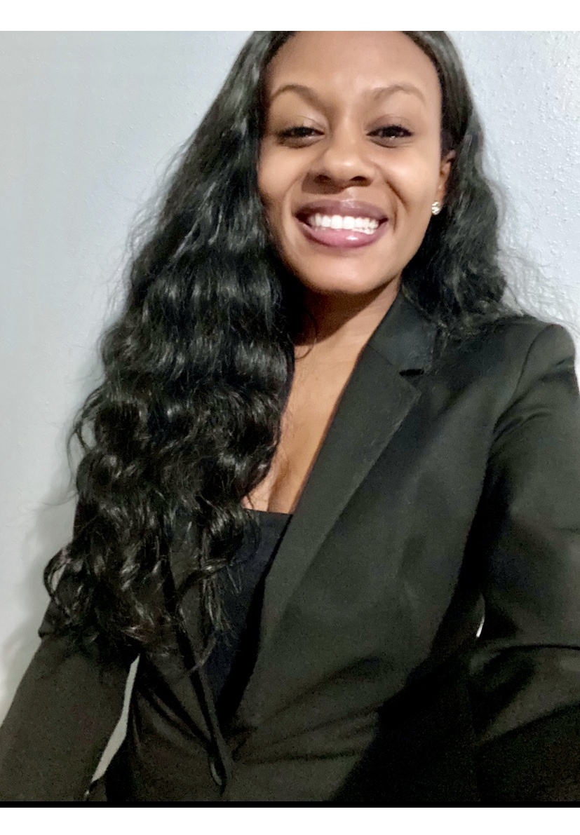 Young woman smiling wearing a black shirt and blazer