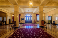 A marble room lit up with yellow lights and maroon carpets