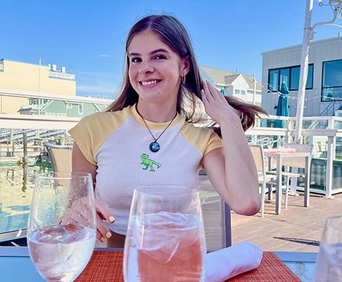 Young woman smiling on a rooftop sitting at a table