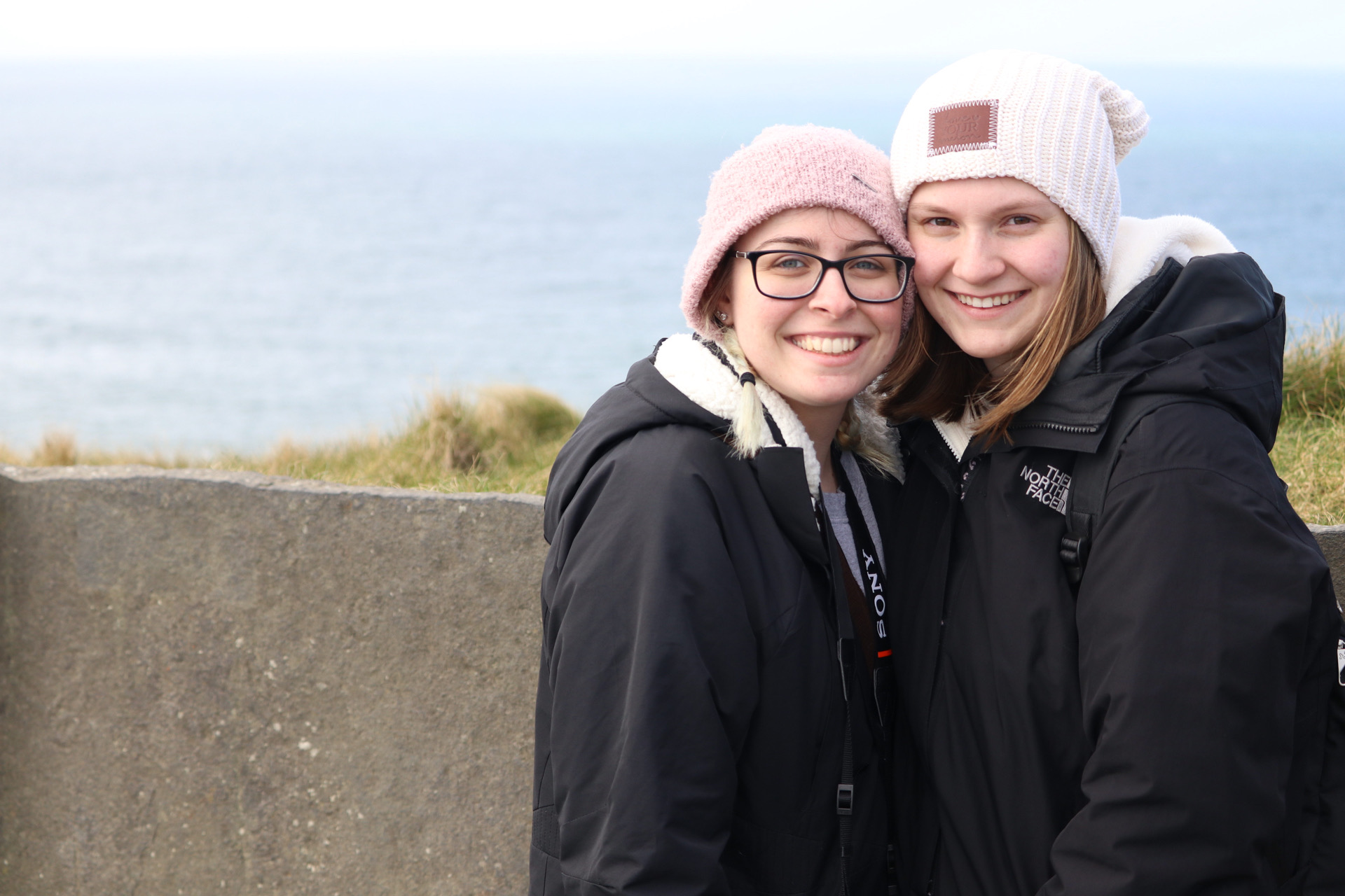 Two young women standing close together.