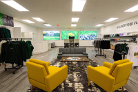 Three TVs with Marywood logos and mottos fill the wall and Marywood-themed clothing are racked around the floor