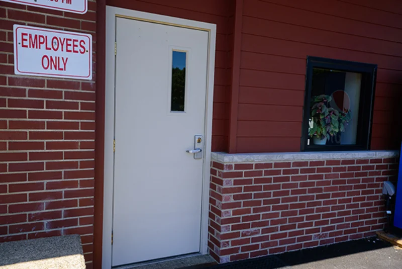 A white door to the brick building that is the Maintenance Building and Power Plant