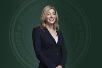 Marywood's 13th President Lisa A. Lori is pictured in a dark blue suit against a green backdrop with the Marywood seal.