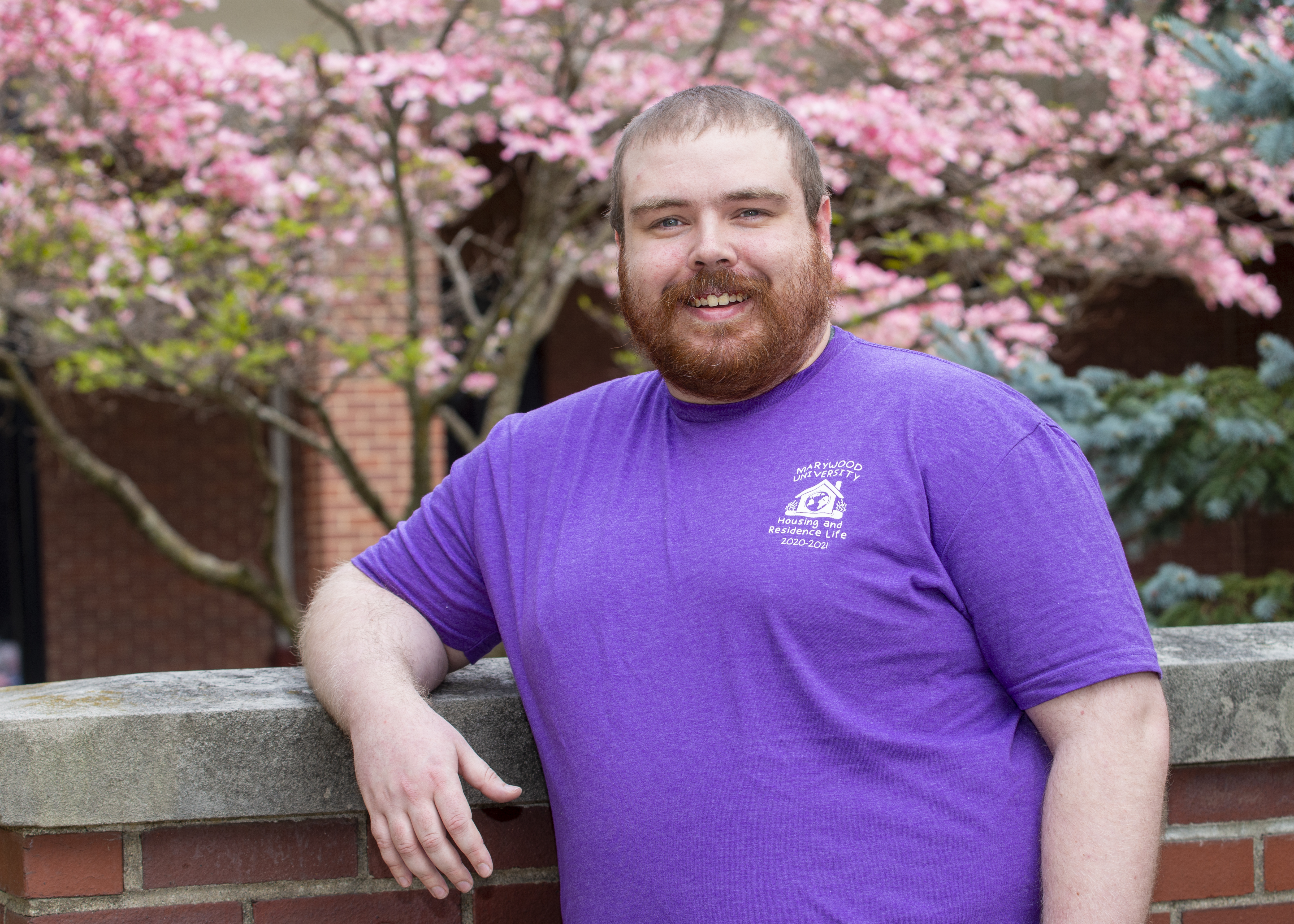 A man leaning against a brick wall.