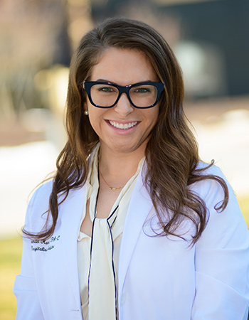 Young woman Physician Assistant student smiling in her white coat.