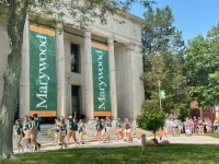 new class orientation group of students walking near liberal arts building steps