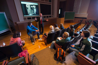 A man presenting to students sitting in rows of seats in the Comerford auditorium