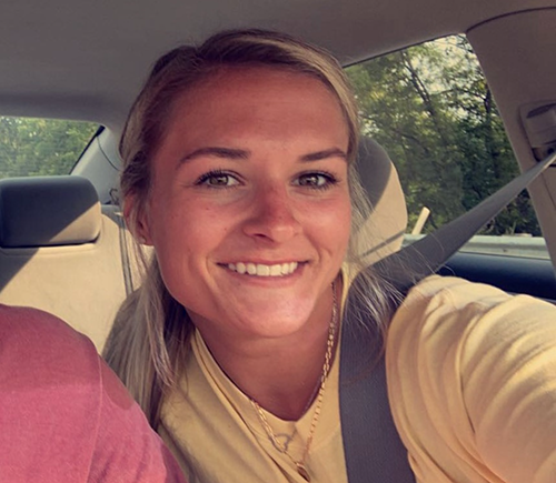 Young woman smiling taking a selfie wearing a yellow shirt