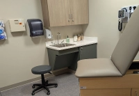 exam room with two chairs, a sink and other tools