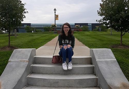 Woman smiling sitting on a pair of steps.