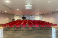 The Cloud room in the architecture building filled with red chairs and a whiteboard on the wall